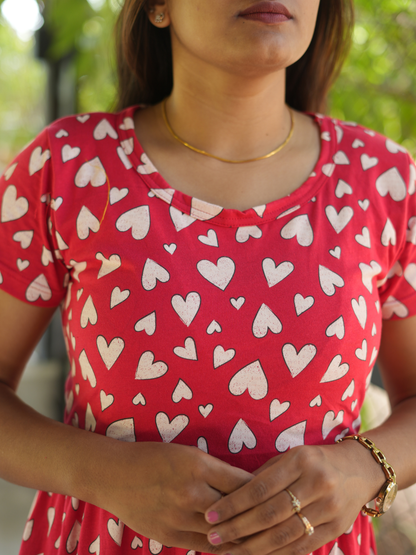 Woman wearing a red dress with white heart patterns outdoors