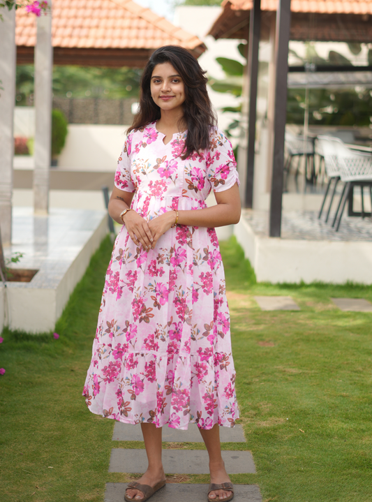 Woman in a pink floral dress standing outdoors on a patio