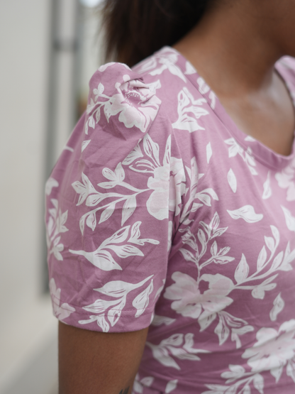 Close-up of a woman wearing a pink floral dress with a blurred background