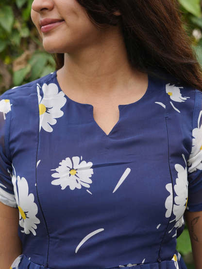 Woman wearing a blue dress with white floral patterns outdoors